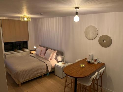 a bedroom with a bed and a table and a tableablish at Quarles 80 - free parking in Noordwijk aan Zee