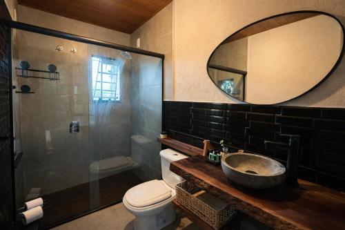 a bathroom with a sink and a toilet and a mirror at Cabana estilo Glamping com Banheiras Quente e Vista às Montanhas in Rio do Sul