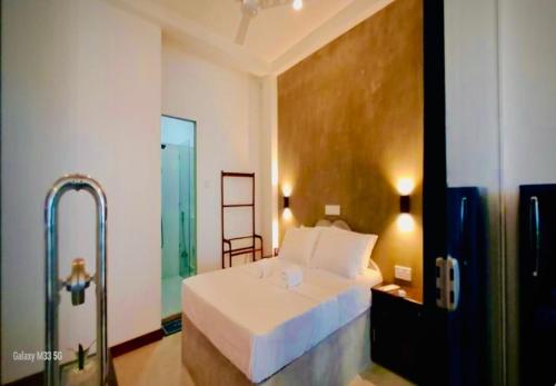 a bedroom with a white bed and a glass door at Villa Jesmin Home - Sea View in Habaraduwa Central