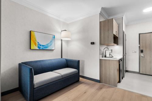 a living room with a blue couch and a kitchen at Holiday Inn Express Hotel & Suites Santa Cruz by IHG in Santa Cruz