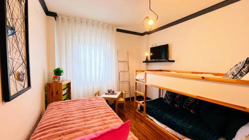 a bedroom with a bunk bed and a tv at Villa Pinheirinhos - Enjoy the Nature & Wild Beaches of Sesimbra! in Sesimbra