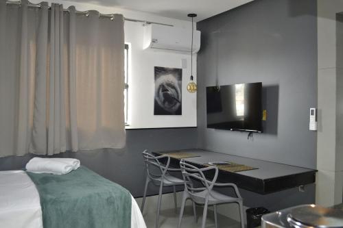 a room with a bed and a table and chairs at Real Grandeza - Studios modernos in Aparecida de Goiânia