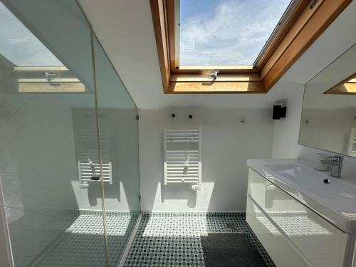 a bathroom with a glass shower and a sink at Suite privativa em apartamento em Algés, Lisboa in Algés
