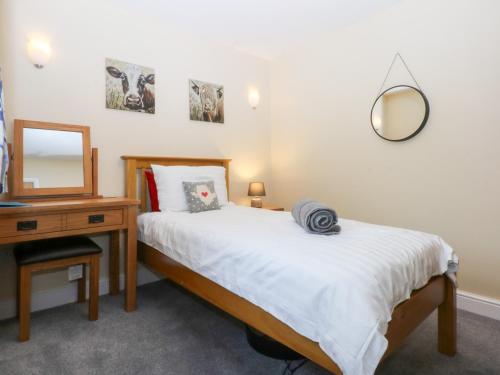 a bedroom with a bed and a mirror and a table at Tregynrig Bach in Cemaes Bay
