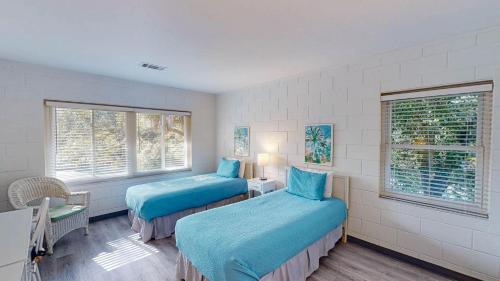 two beds in a room with two windows at Atlantic Breeze #5 in Jekyll Island