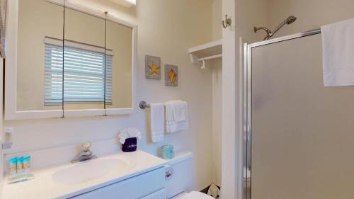 a white bathroom with a sink and a shower at Atlantic Breeze #5 in Jekyll Island
