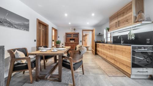 a kitchen and dining room with a wooden table and chairs at Naturhaus Leger in Lenggries