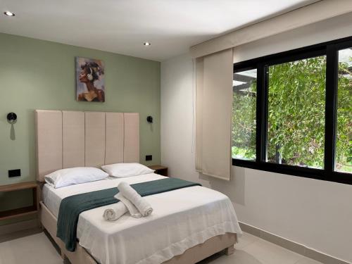 a bedroom with a large bed with towels on it at Arcadia Hotel in Cartagena de Indias