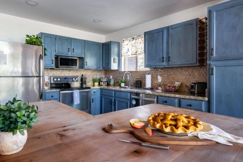 a kitchen with blue cabinets and a wooden table at Cozy Chalet in the Pines in Munds Park