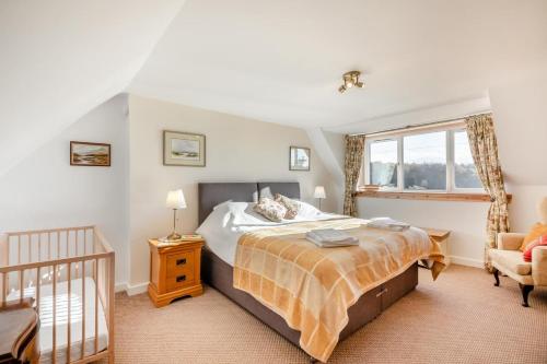 a bedroom with a bed and a crib at 2 Bed in Duns oc-c34024 in Duns