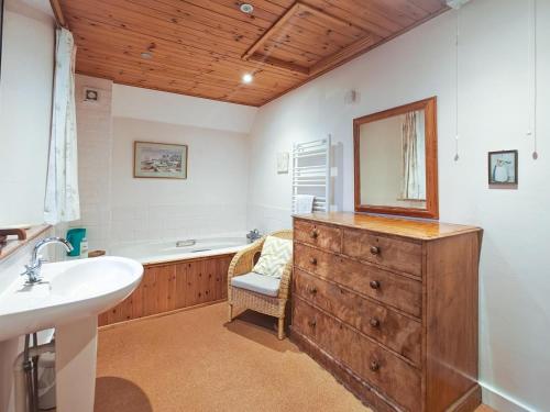 a bathroom with a sink and a dresser with a mirror at 4 Bed in Lower Bockhampton oc-t34129 in West Stafford