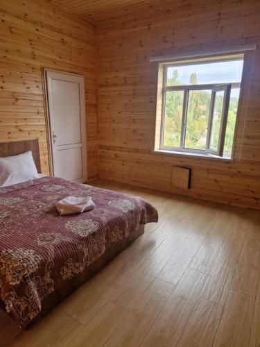 a bedroom with a bed and a window at Brick Villas in Qusar