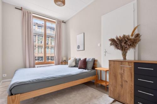 a bedroom with a bed and a window at Bistro Walk Apartment in Lausanne