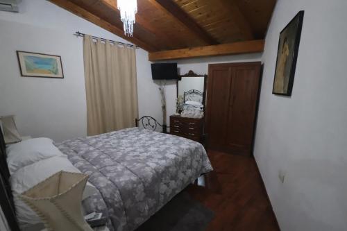 a bedroom with a bed and a wooden ceiling at Casa India in Assemini