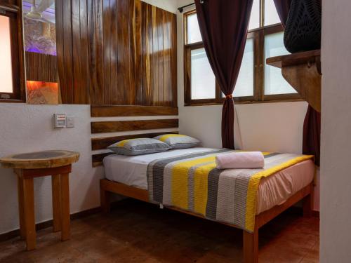 a small bed in a room with windows at Las Barracas de la Barra in Malucano
