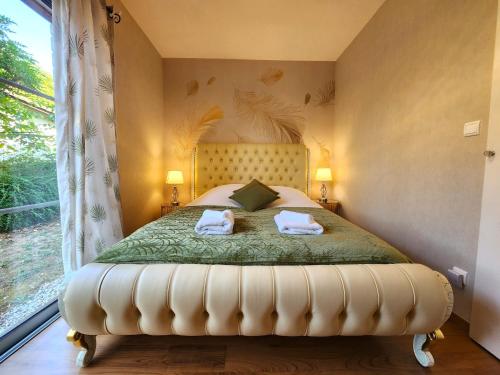 a bedroom with a large bed with two towels on it at Symphony - in Saint-Emilion in Saint-Émilion