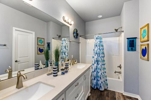 a bathroom with two sinks and a large mirror at Steps to the Beach l Modern Interior in Crystal Beach