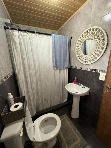 a bathroom with a toilet and a sink at Casa del parque in Oberá