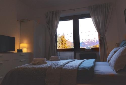 a bedroom with a bed and a large window at Donovaly Kamzík in Donovaly