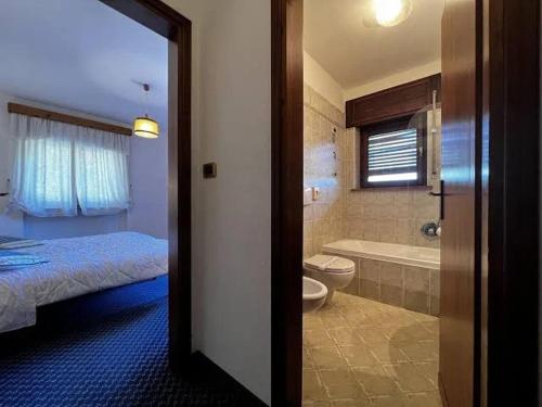 a bathroom with a bed and a toilet and a tub at Hotel Bosco Verde in Mareson