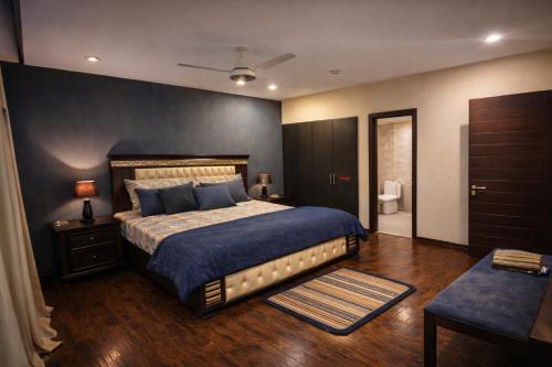 a bedroom with a large bed and a bathroom at The Nest Apartment in Rawalpindi