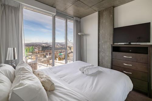 a bedroom with a large bed with a large window at Les Immeubles Charlevoix - Le 760-415 in Quebec City