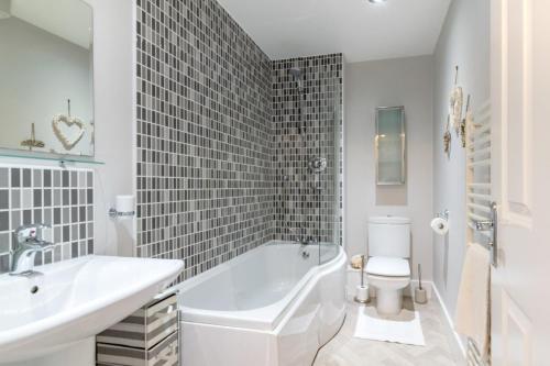 a bathroom with a tub and a sink and a toilet at 2 Bed in Beadnell oc-gd0376 in Beadnell