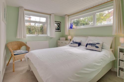 a bedroom with a white bed and two windows at 4 Bed in Reydon oc-fll in Reydon