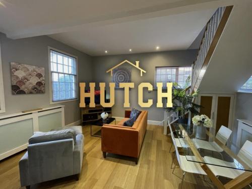 a living room with a hotel sign on the wall at Luxury 3-bed Victorian Townhouse Hosted by Hutch Lifestyle in Leamington Spa