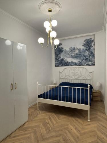a bedroom with a bed and a chandelier at Katerina Apartman in Gyula
