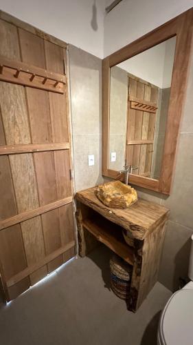 a bathroom with a wooden sink and a mirror at Tupinambá Pousada e Hostel in Caraíva