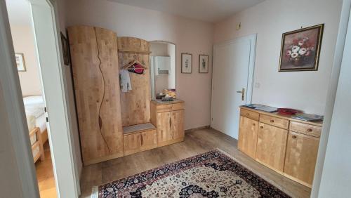 a bathroom with wooden cabinets and a large mirror at Haus Kraller-Urlaub mit Seeblick in Millstatt
