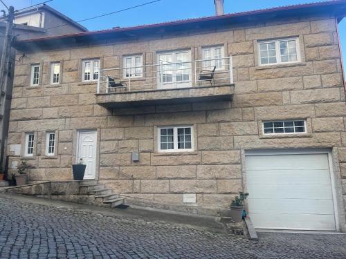 a brick building with a white garage door on a street at Casa Miná in Montalegre