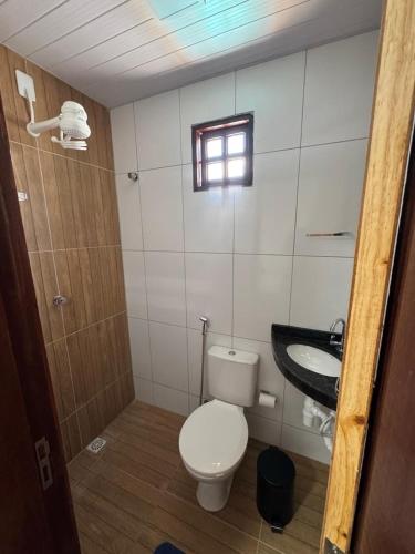 a small bathroom with a toilet and a sink at Chácara Julião da usina in Juazeiro do Norte