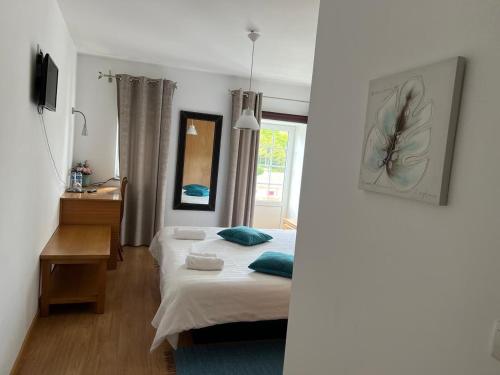 a bedroom with a bed and a desk and a window at Casa Miná in Montalegre