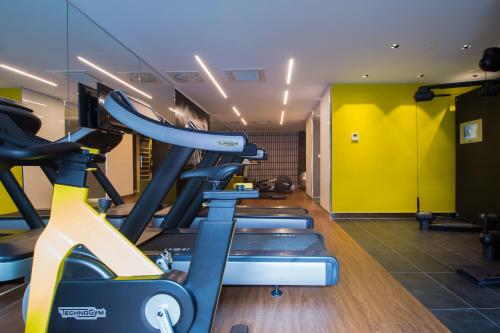a gym with a row of tread machines in a room at Mercure Krakow Stare Miasto in Kraków