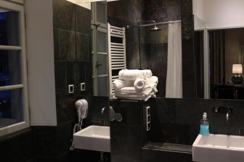 a bathroom with two sinks and a mirror and towels at Klosterhof Weingut BoudierKoeller in Stetten