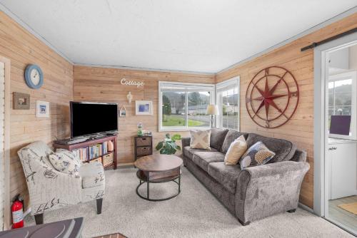 a living room with a couch and a tv at Coho Cottage in Rockaway Beach