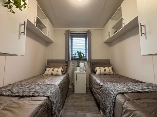 two beds in a small room with a window at Noa aan Zee in Westerland