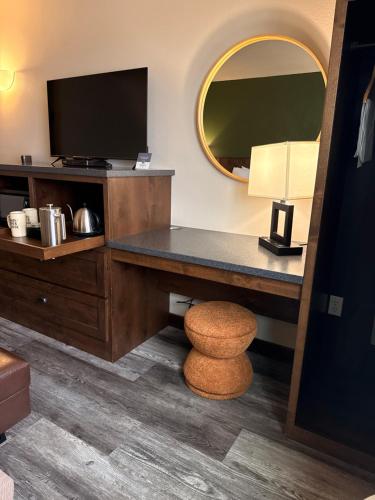 a hotel room with a desk with a television and a stool at Ninepipes Lodge in Polson