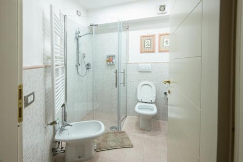 a bathroom with a toilet and a shower and a sink at Egea Beach House in Lido di Camaiore
