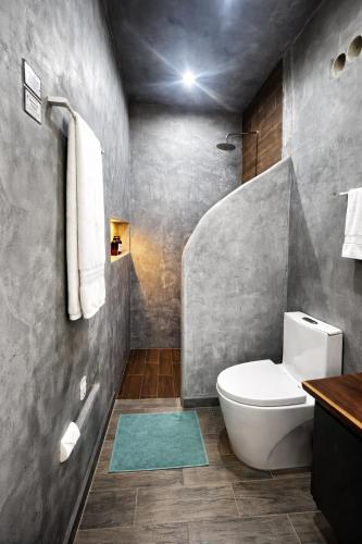 a bathroom with a white toilet and a sink at Kasa Nikte in Tulum