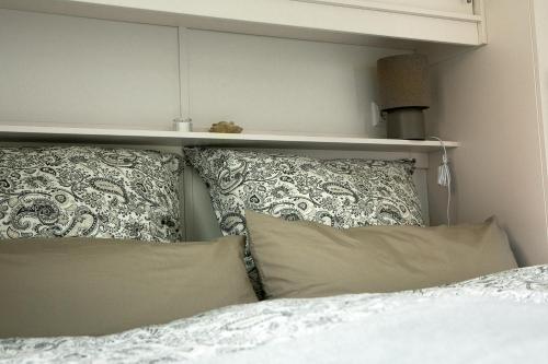 a bed with pillows and a shelf above it at Hof Eichendiek Time Out Village- Haus Naturruhe in Blekendorf