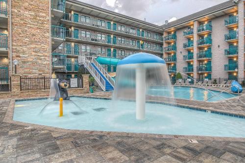 a pool with a water slide in front of a building at Accommodations By Willow Brook Lodge in Pigeon Forge
