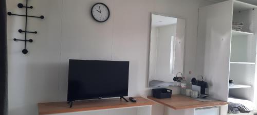 a television sitting on a table in a living room at Surf Shack 3 - Zimmer am Strand, Parkplatz, WLAN, Kiten, Surfen, Chillen im Gemeinschaftsgarten, Naturstrand, Restaurants und Geschäfte in 5 Minuten erreichbar, lockere Atmosphäre in Dahme