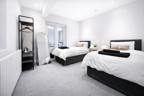 a bedroom with two beds and a mirror at The Fratton Apartment with parking in Portsmouth