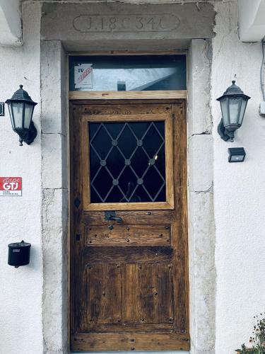 a wooden door on a building with two lights at Auberge La Cléa in La Pesse
