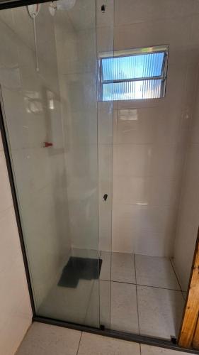 a shower with a glass door in a room at Casa ceu in Florianópolis