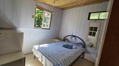 a small bedroom with a bed with a blue blanket at Casa ceu in Florianópolis