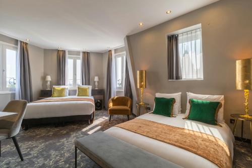 two beds in a hotel room with green pillows at Leonardo Hotel Amsterdam Museum Quarter in Amsterdam